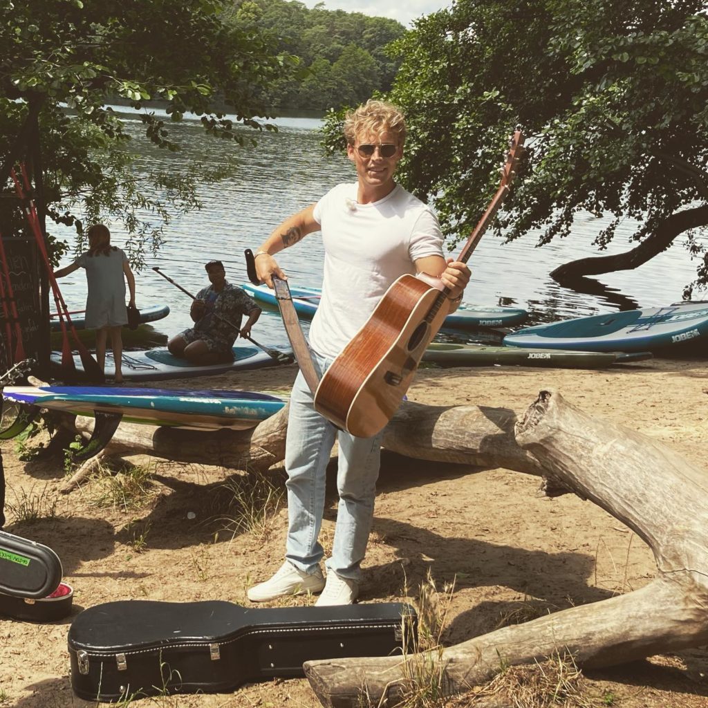 Superstar Christopher mit Gitarre beim Stehpaddler SUP Verleih Schlachtensee